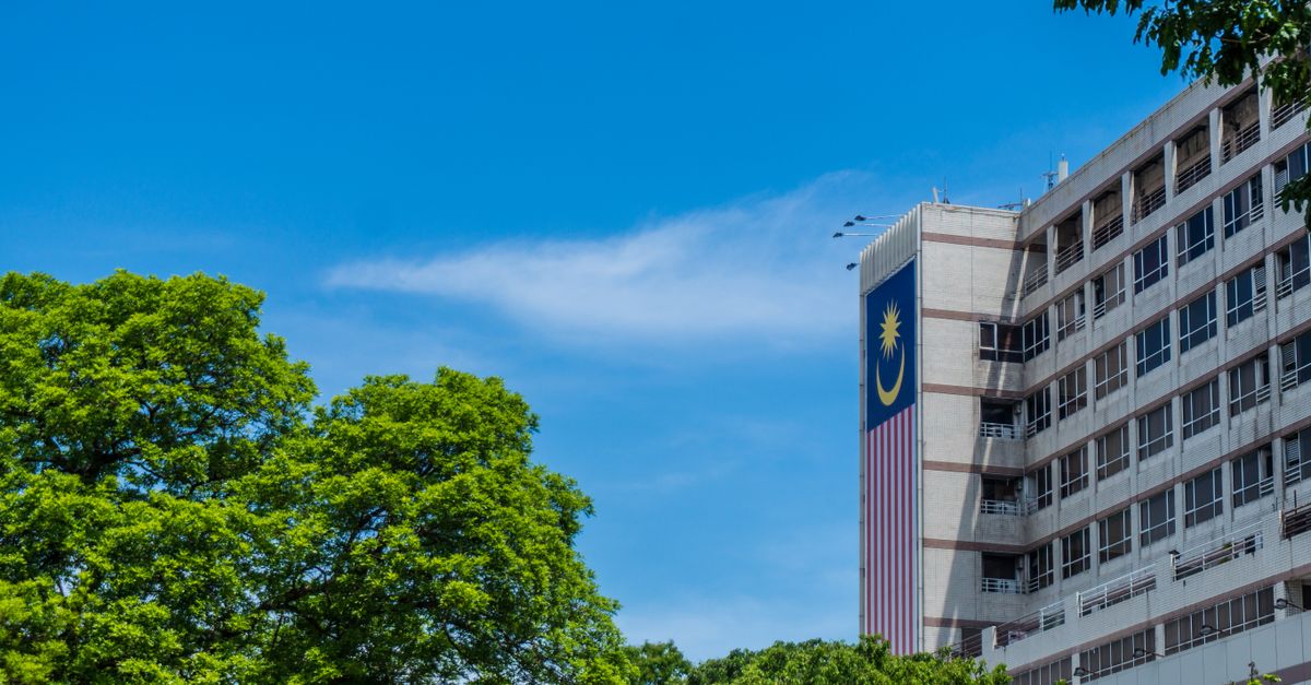 Drapeau malaisien sur la façade d’un bâtiment sous un ciel bleu