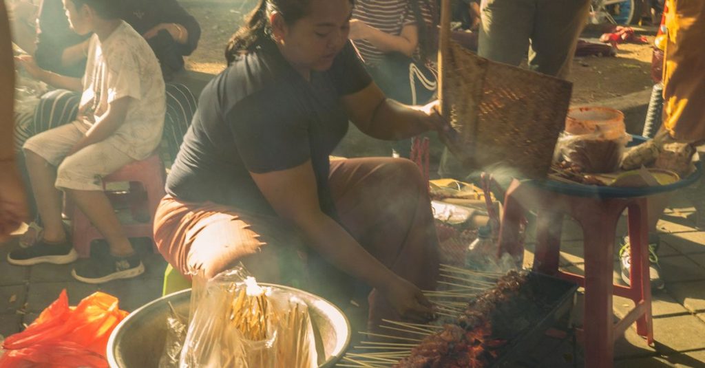 Vendeuse préparant des brochettes sur un étal de rue