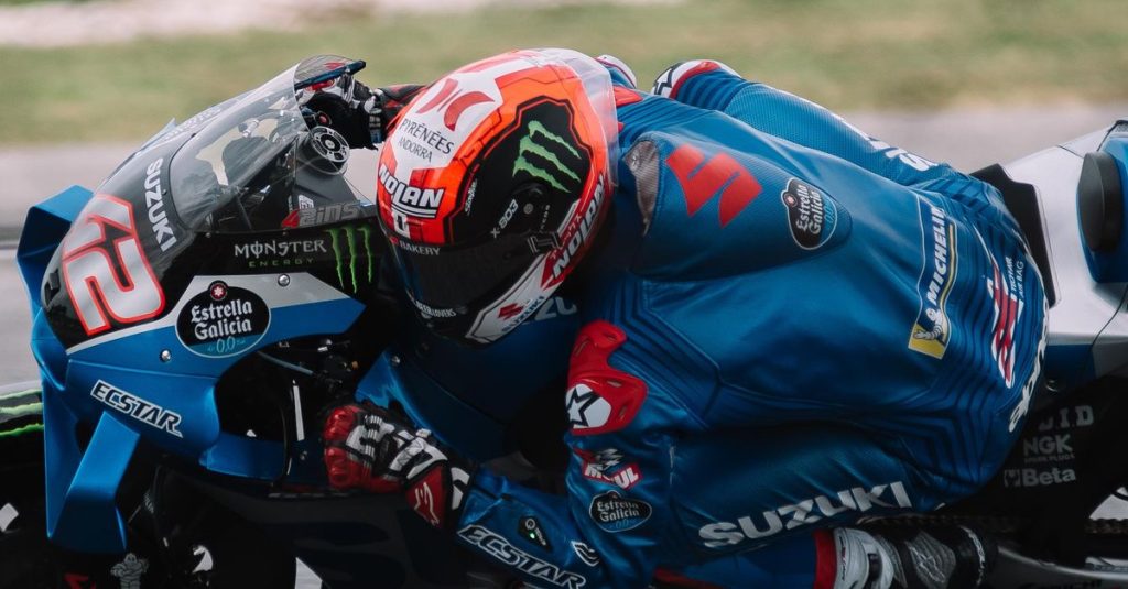 Pilote de moto en combinaison bleue penché dans un virage de course
