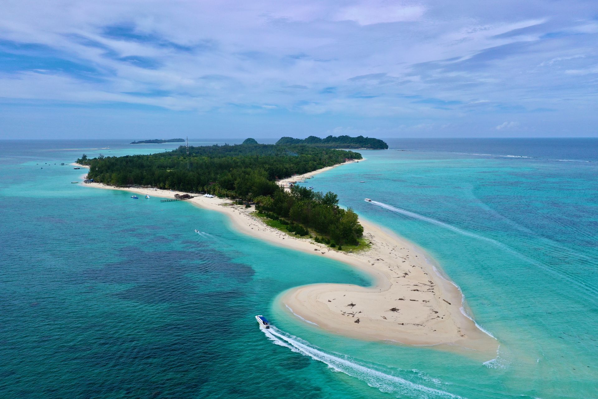 Plage de sable blanc et eaux turquoise du parc marin Tunku Abdul Rahman, avec des îles verdoyantes en arrière-plan